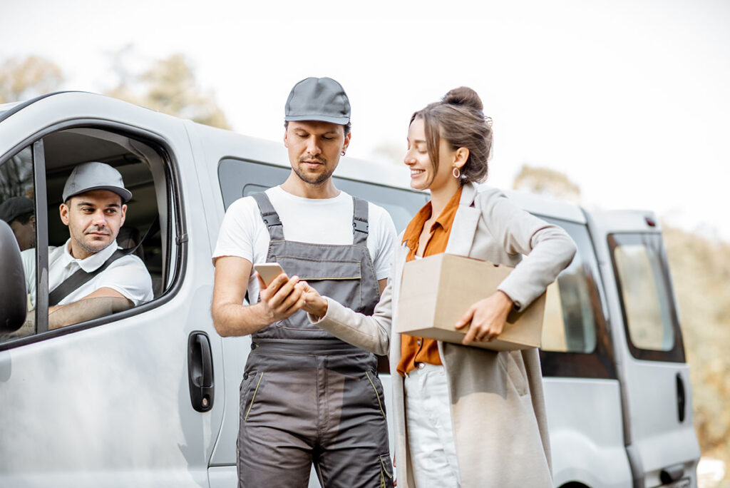 Delivery company employees delivering goods to a client by car
